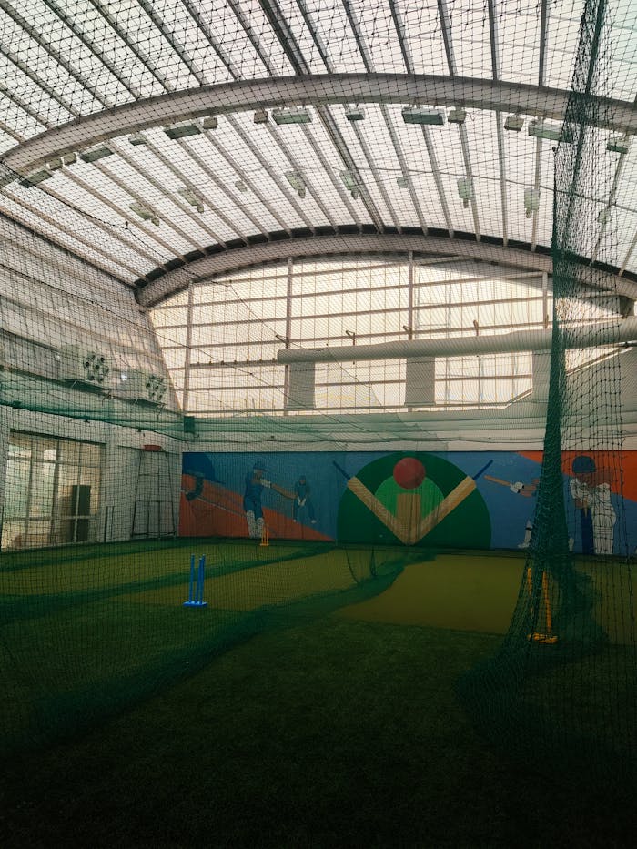 hero-img-02 Cricket practice facility with vibrant murals in Dharamshala, India.