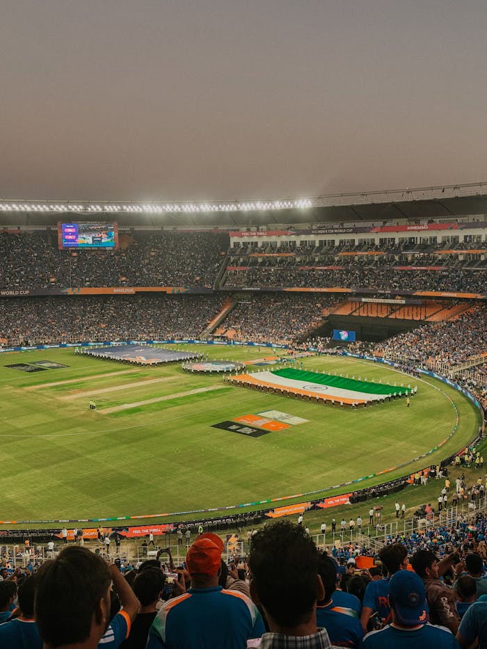 A vibrant cricket match at Narendra Modi Stadium with a packed crowd in Ahmedabad, India.